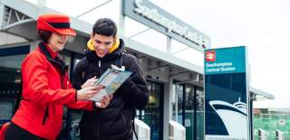 Two people looking down at a map outside Southampton Central Train Station