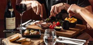 Close up of person cutting up a steak in a restaurant