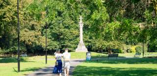 Two people in the distance walking in Queens Park
