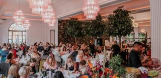 Groups of women dining at large round tables at The Grand