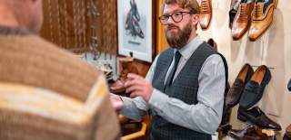 A person holding a shoe in W J French & Sons shoe shop showing a customer