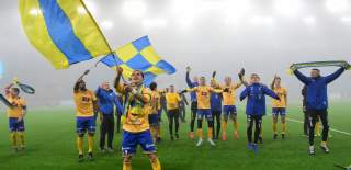 Glade fotballspillere fra Jerv feirer opprykk