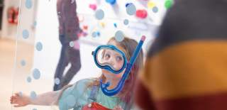 Young girl pretending to be a diver at Eureka! Science + Discovery in Seacombe, Wallasey, Wirral