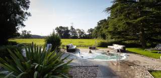 People sitting outside in a sunken pool in green surroundings