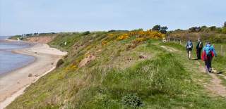 People walking along Thurstaston Coast