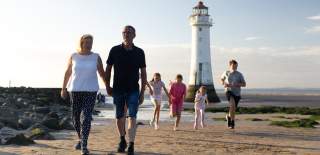 Family Walking along New Brighton Beach past Lighthouse