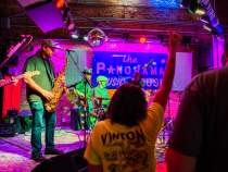 jazz musicians play onstage with saxophone, guitar, keyboard, and drums at panorama music house