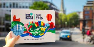 Hand holding a Love Bristol Gift Card shopping voucher on Bristol Bridge, central Bristol - credit Bristol BIDs