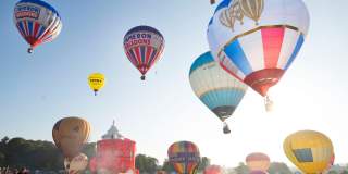 A group of balloons lifting off in a mass ascent at Bristol International Balloon Fiesta - credit Paul Box