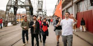 A group of people on the Cider Box walking tour of Bristol outside the M Shed local history museum on Bristol's Harbourside - credit Yuup