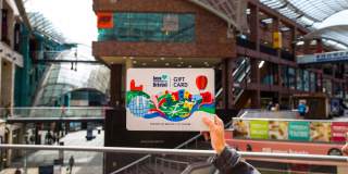 Hand holding a Love Bristol Gift Card shopping voucher in Cabot Circus, central Bristol - credit Bristol BIDs