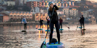 A group of people stand-up paddleboarding in Bristol Harbour - credit Paul Box