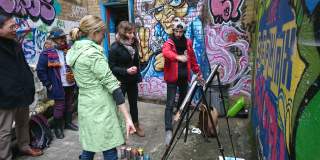 A group having a go at creating street art on the Where the Wall tour in central Bristol - credit Where The Wall