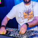Man working a DJ table in a black light room