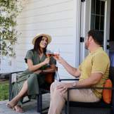 A couple sitting on a porch, enjoying a glass of wine