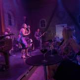 A jazz band performs on the dimly lit stage at The Merc