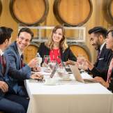 A group of professionals holds a meeting in a wine cellar
