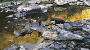 Men crossing the Big South Fork National River with their bikes