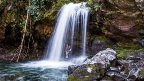 Hikers standing under the Grotto Falls on Trillium Gap Trail near Knoxville
