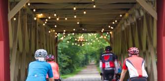 Cyclists crossing a covered wooden bridge