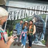 People Standing in front of a Gatlinburg mural