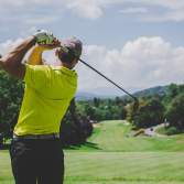 Man taking a golf swing at a golf course in Beaumont, TX