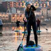 A group of people stand-up paddleboarding in Bristol Harbour - credit Paul Box