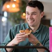 A male university student eating a pizza at Bambalan - credit Bambalan