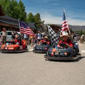Go Karts with American Flags roll Grand Ave. in a parade