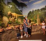 family observing the dinosaur exhibit at the Creation Museum