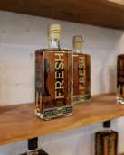 Bottle of bourbon lined up on a wooden shelf