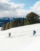 a group of people skiing down a mountain in Cody Wyoming