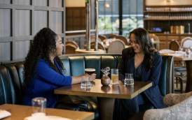 Two women sitting at a table laughing