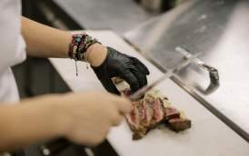 Chef cutting meat on cutting board