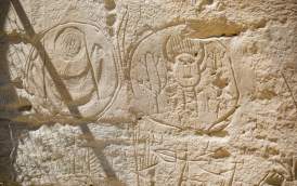 Engravings shown on rock wall up close