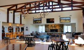 Casanel Vineyards tasting room with exposed wood beams, chandeliers and a stone fireplace in Leesburg, Virginia