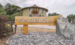 Wooden Fabbioli Cellars entrance sign in front of the round tasting room in Leesburg, Virginia