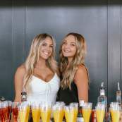 two women serving mimosas for the Stack N Style Event.