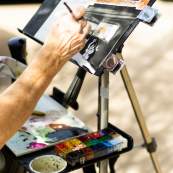 Painter painting on the sidewalk in downtown during the Art Stomp event in 2025