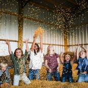 Children throw corn and play in the large corn bin at Helena Hollow.