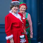 ladies dressed up as mrs. claus and an elf for the holidays at light up downtown
