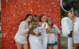 Group posing with props at the Photo booth during the White Linen event during Juneteenth
