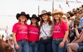 Photo of Miss Brown County Winner with 3 other ambassadors in the Rodeo crowd, posing for the camera.