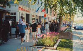 Crowd walking on sidewalk in front of heritage shops