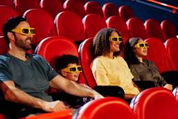 A family of four - Dad, son, mom, daughter sat in a cinema with 4D glasses on