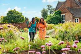 Two ladies looking at spring flowers in front of Winterbourne House and Garden