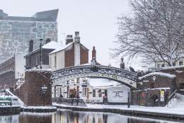 Winter in Birmingham, snow on the ground and bridge with the Regency Wharf and Cube in the background