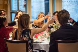 people at a dining table toasting with a glass of bubbly