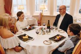 festive round dinner table and family having their pudding