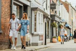 A couple walking hand-in-hand through Beverley carrying shopping bags